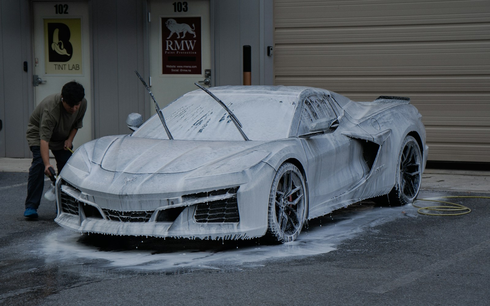 Exterior hand wash with thick soap foam on a sports car